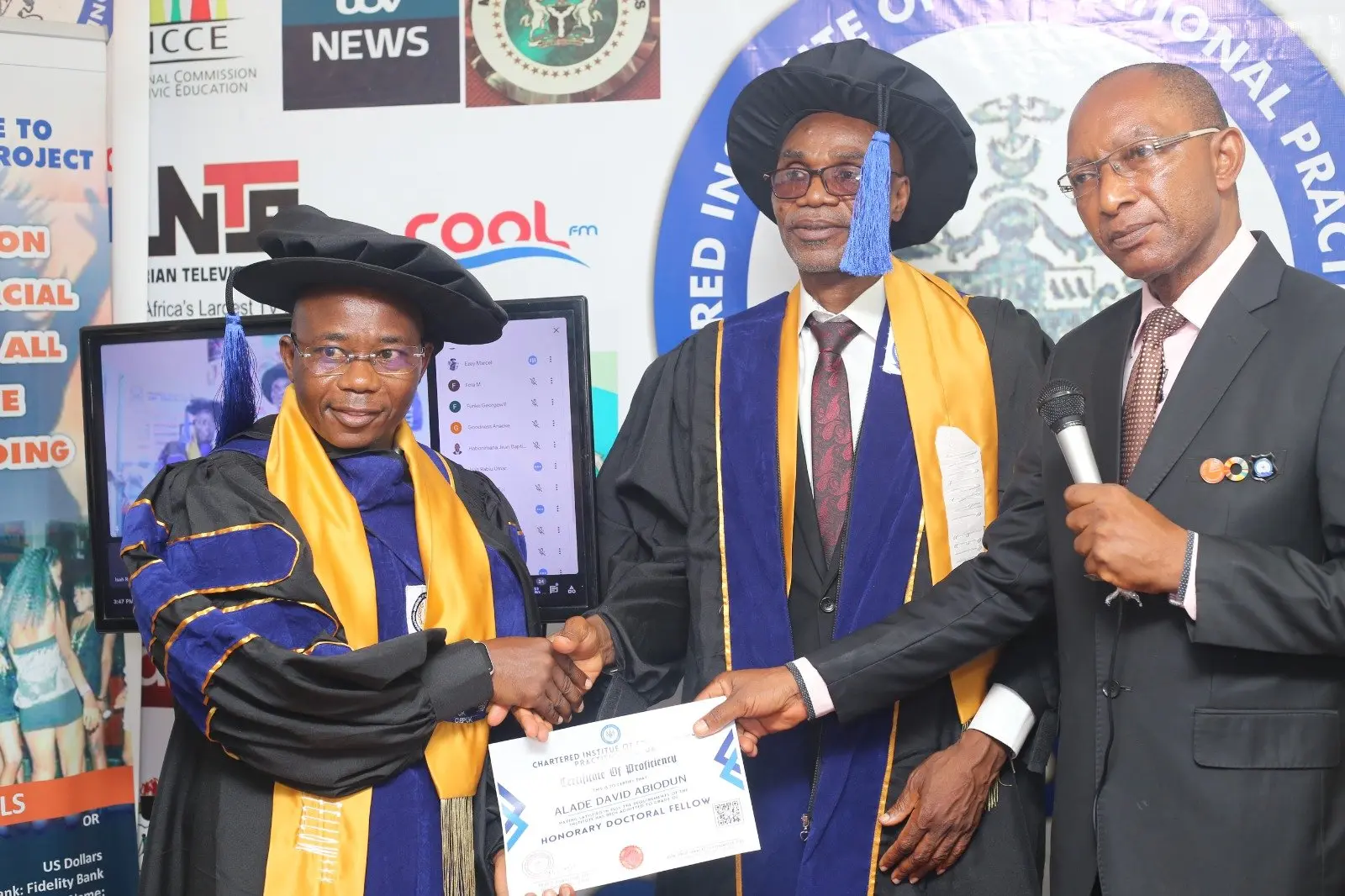An honorary doctoral fellow with a framed award