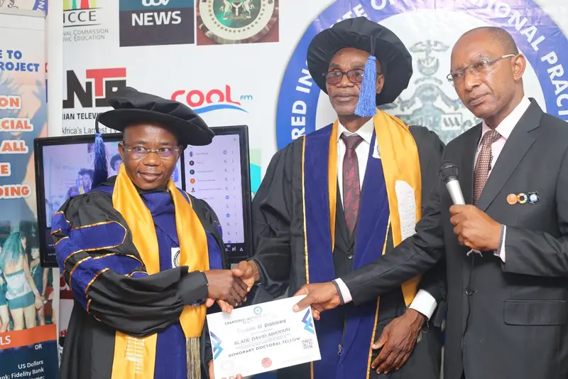 An honorary doctoral fellow with a framed award
